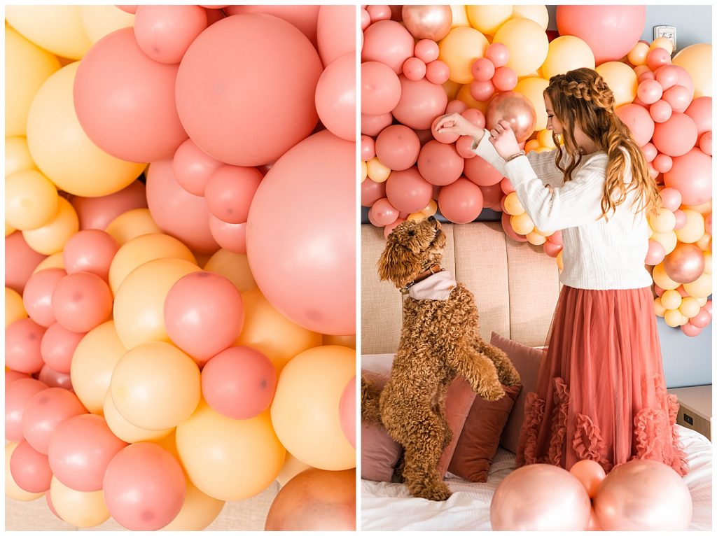 Girl and dog dancing on bed with balloons on valentine's Day