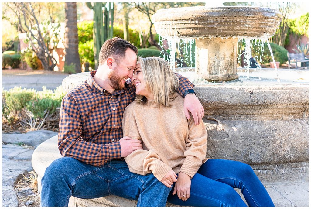 couple cuddling in front of fountain at Rancho Manana