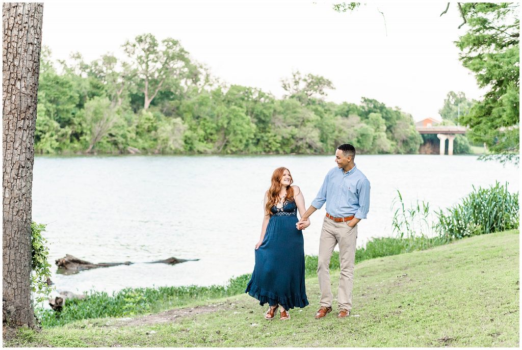 Man and woman walking by Brazos River at Cameron Park in Waco, Texas engagement photos