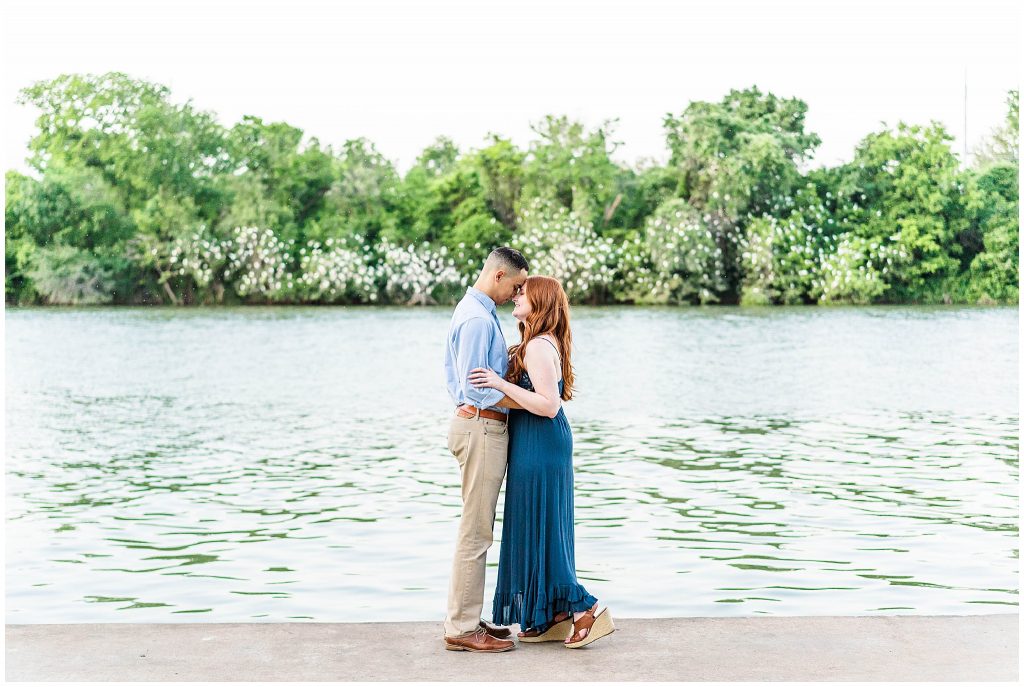 Man and woman cuddling by Brazos River at Cameron Park in Waco, Texas engagement photos