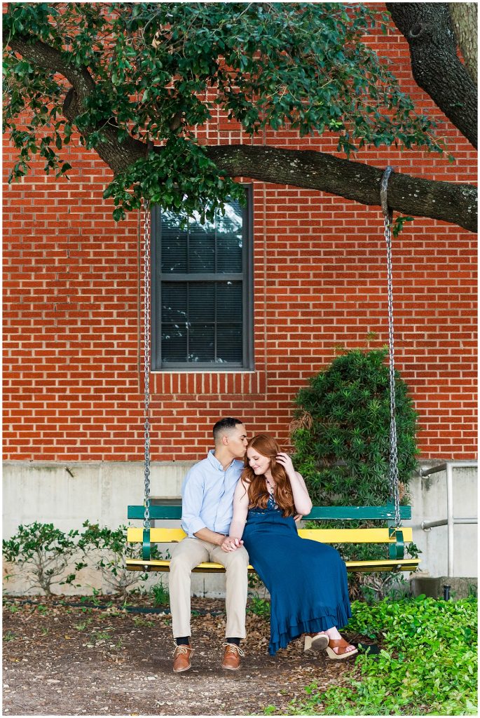 Couple sitting on gold and green swing at Baylor University in Waco, Texas engagement photos