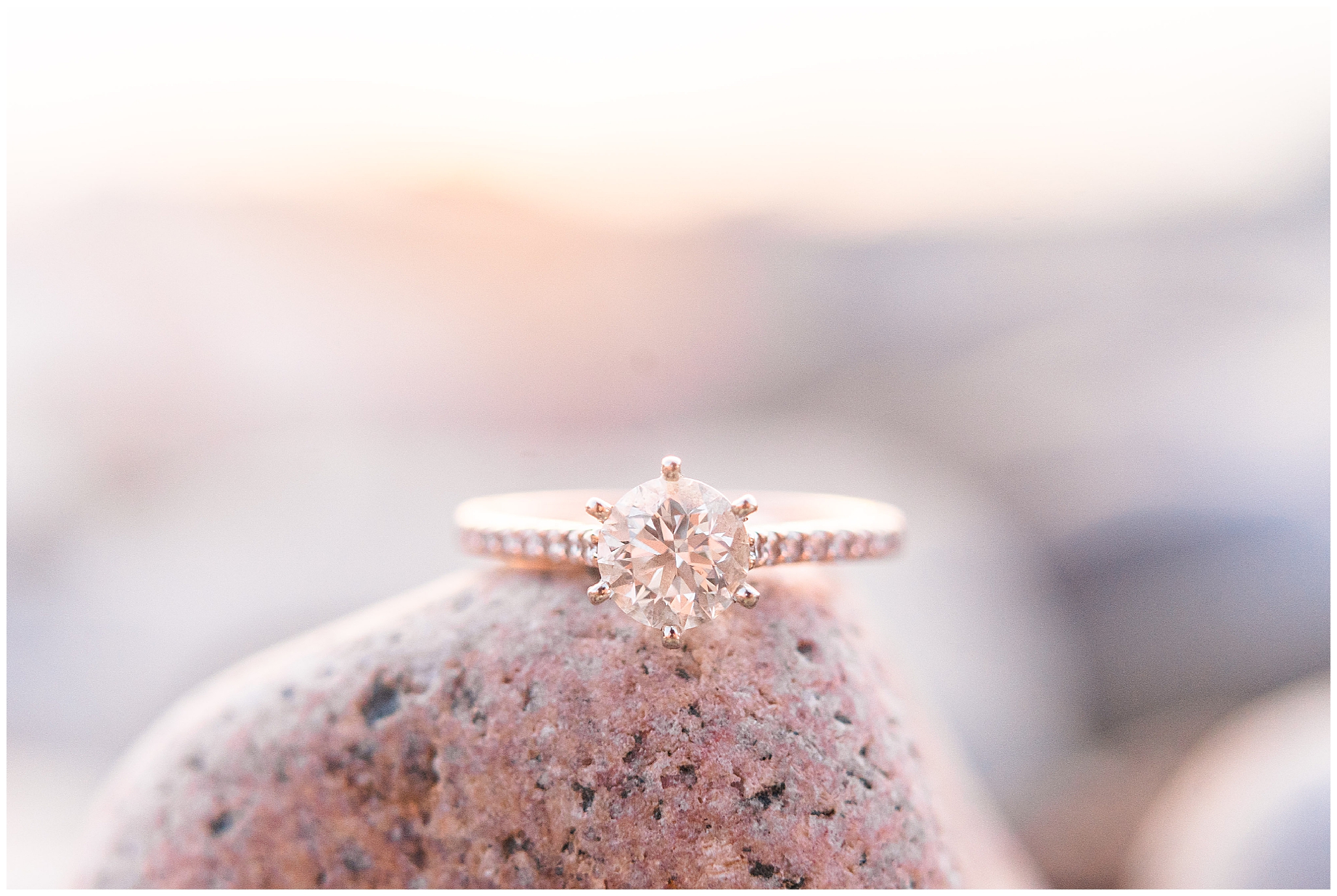 Engagement ring illuminated by the pink hues of the sunset on the beach in Cleveland's Sims Park